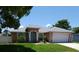 Charming single-story home featuring a manicured lawn and a light blue front door at 404 Oakmount Rd, Clearwater, FL 33765