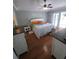 Light-filled main bedroom featuring a ceiling fan, wood floors, and windows for natural light at 404 Oakmount Rd, Clearwater, FL 33765