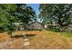 Secluded backyard with stepping stones leading to the home and a cozy outdoor seating area surrounded by trees at 41 W Boyer St, Tarpon Springs, FL 34689