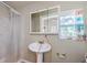 Bathroom showcasing a pedestal sink, mirrored cabinet, shower with curtain, and a window at 41 W Boyer St, Tarpon Springs, FL 34689