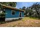 Charming exterior view of a blue house featuring a quaint window and inviting entry door at 41 W Boyer St, Tarpon Springs, FL 34689