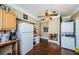 Vintage kitchen with an older refrigerator, washer, dryer, and dark hardwood floors at 41 W Boyer St, Tarpon Springs, FL 34689