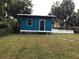 Exterior view of a shed featuring blue siding and a simple design, set in a well-maintained grassy yard at 41 W Boyer St, Tarpon Springs, FL 34689