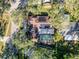 Aerial shot of a home showcasing a screened-in pool, solar panels, and mature trees at 44 Pinewood Cir, Safety Harbor, FL 34695