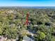 Aerial view of a secluded property surrounded by lush trees and greenery, with glimpses of a lake in the background at 44 Pinewood Cir, Safety Harbor, FL 34695