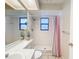 Bright bathroom with a shower, a window, and a large mirror above the sink and toilet at 44 Pinewood Cir, Safety Harbor, FL 34695