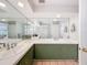Bright bathroom features double sinks, a large mirror, and olive green cabinets at 44 Pinewood Cir, Safety Harbor, FL 34695