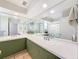 Bright bathroom features double sinks, a large mirror, and olive green cabinets at 44 Pinewood Cir, Safety Harbor, FL 34695