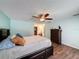 Inviting bedroom with wood floors, a ceiling fan, and ensuite bathroom and walk-in closet at 44 Pinewood Cir, Safety Harbor, FL 34695