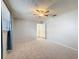 Bright bedroom features neutral carpet, a ceiling fan, and a window with blue curtains at 44 Pinewood Cir, Safety Harbor, FL 34695