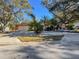 Inviting home exterior featuring a front yard with mature trees, a wide driveway, and a welcoming atmosphere at 44 Pinewood Cir, Safety Harbor, FL 34695