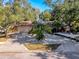 A well-maintained home with a spacious driveway, stone accents, and tropical landscaping enhancing its curb appeal at 44 Pinewood Cir, Safety Harbor, FL 34695