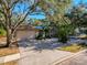 Charming single-story home boasting a stone facade, two-car garage, and beautifully manicured front yard at 44 Pinewood Cir, Safety Harbor, FL 34695