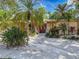 A home's front entrance featuring a tropical landscaped yard, stone veneer and double doors at 44 Pinewood Cir, Safety Harbor, FL 34695