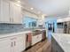 Stylish kitchen featuring stainless steel appliances and sink, granite countertops, and bright backsplash at 44 Pinewood Cir, Safety Harbor, FL 34695