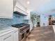 Close up of the gourmet kitchen showcasing a high-end range, tile backsplash, and custom vent hood at 44 Pinewood Cir, Safety Harbor, FL 34695