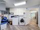 Laundry room with white washer, dryer, cabinets, and sink at 44 Pinewood Cir, Safety Harbor, FL 34695