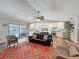 Open-concept living room that flows into the kitchen, with sliding doors to the outdoor pool at 44 Pinewood Cir, Safety Harbor, FL 34695