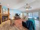 Cozy living room with a brick fireplace, wood flooring, and sliding glass door to the pool at 44 Pinewood Cir, Safety Harbor, FL 34695