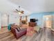 Cozy living room featuring a stone fireplace, ceiling fan, and hardwood floors at 44 Pinewood Cir, Safety Harbor, FL 34695