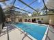 Screened-in pool featuring a sparkling swimming pool, covered seating area, and attached spa at 44 Pinewood Cir, Safety Harbor, FL 34695