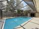 Sparkling pool surrounded by a screened enclosure and a well-maintained yard at 44 Pinewood Cir, Safety Harbor, FL 34695