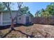 Backyard featuring storage shed, wooden fence, and mature trees, offering privacy and space for outdoor activities at 506 Summerwood Ct, Tarpon Springs, FL 34689