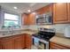 Well-lit kitchen with wood cabinets, stainless steel appliances, and a window over the sink at 506 Summerwood Ct, Tarpon Springs, FL 34689