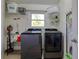 Bright laundry room with modern washer and dryer, storage shelves, and a window for natural light at 506 Summerwood Ct, Tarpon Springs, FL 34689
