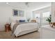 Bright, spacious bedroom featuring a bed with neutral linens and a chair bathed in natural light from shuttered windows at 5351 Bridge St # 9, Tampa, FL 33611