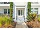 Inviting entryway with manicured plants and gray steps leading to a glass front door at 5351 Bridge St # 9, Tampa, FL 33611