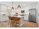 Modern white kitchen with stainless steel appliances and a center island with seating at 5351 Bridge St # 9, Tampa, FL 33611