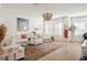Bright living room with white furniture, layered rug, and modern chandelier at 5351 Bridge St # 9, Tampa, FL 33611