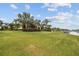 Sprawling green backyard with palm trees and waterfront views on a sunny day at 5405 Tybee Island Dr, Apollo Beach, FL 33572