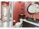 Modern powder room with a vessel sink, vibrant red walls, and stylish accents at 5405 Tybee Island Dr, Apollo Beach, FL 33572