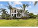 Stunning exterior view of a luxurious home with manicured lawns and mature palm trees at 5405 Tybee Island Dr, Apollo Beach, FL 33572