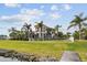 Expansive lawn, palm trees, and a charming two-story house by the water at 5405 Tybee Island Dr, Apollo Beach, FL 33572