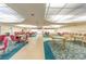 An open game room with card tables and chairs, with carpeted floors and overhead lighting at 5521 80Th N St # 110, St Petersburg, FL 33709