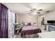 Comfortable bedroom featuring purple accents, a ceiling fan, and light wood-look flooring at 602 Lynchburg Dr, Brandon, FL 33511