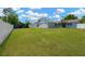 Expansive backyard featuring a lush green lawn, shed, and partial view of the home's exterior under a blue sky at 607 Carolyn Dr, Brandon, FL 33510