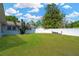 Expansive backyard with lush green lawn, mature trees, and a white fence, perfect for outdoor activities at 607 Carolyn Dr, Brandon, FL 33510