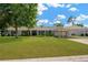Charming single-story home with lush front lawn, mature tree, and attached carport at 607 Carolyn Dr, Brandon, FL 33510