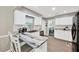 Bright kitchen with white cabinets, a dark sink, updated appliances, and bar seating with unique countertop design at 607 Carolyn Dr, Brandon, FL 33510