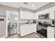 Updated eat-in kitchen featuring stainless steel appliances, white cabinetry, and wood flooring at 607 Carolyn Dr, Brandon, FL 33510