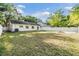 Large fenced backyard with well-maintained lawn and mature trees, ideal for outdoor activities at 7012 S Trask St, Tampa, FL 33616