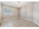 Bright bedroom featuring neutral paint, tile flooring, a chandelier and a window with bright natural light at 7012 S Trask St, Tampa, FL 33616