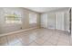 Sunny bedroom featuring two windows, tiled floors, and built-in closets at 7012 S Trask St, Tampa, FL 33616
