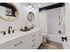 An elegant bathroom featuring a white dual sink vanity and black framed round mirrors at 7404 Bay Dr, Tampa, FL 33635