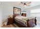 This bedroom includes light wood floors, a ceiling fan, and a wood-stained dresser at 7404 Bay Dr, Tampa, FL 33635