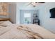 This bedroom featuring a ceiling fan, large windows, and a mini-fridge at 7404 Bay Dr, Tampa, FL 33635